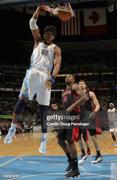 Nene of the Denver Nuggets dunks the ball in front of Amir Johnson of the Toronto Raptors at the Pepsi Center on March 21, 2011 in Denver, Colorado....