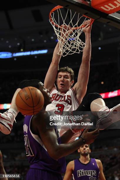 Omer Asik of the Chicago Bulls dunks the ball over Jason Thompson of the Sacramento Kings at the United Center on March 21, 2011 in Chicago,...