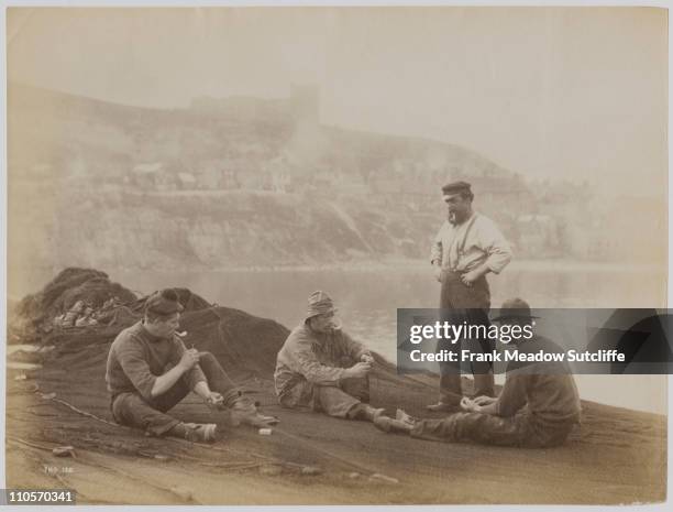 Fishermen mending their nets in Whitby, North Yorkshire, circa 1890.