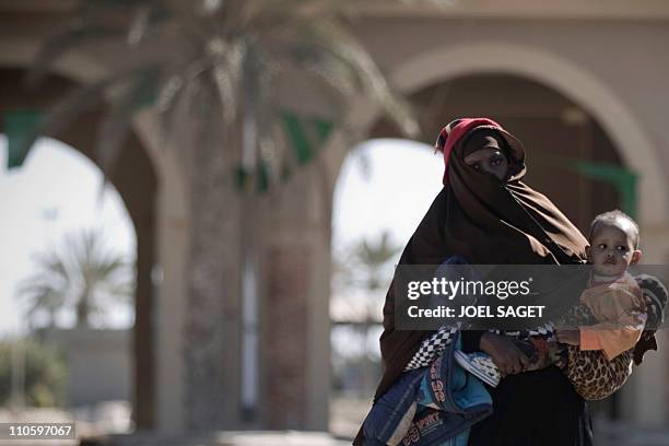 Woman fleeing Libya with her infant crosses the border into Tunisia at the Ras Jedir post on March 9, 2011. Libya's neighbours Tunisia, Algeria and...