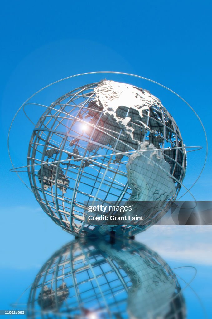 Huge globe reflected in pond.