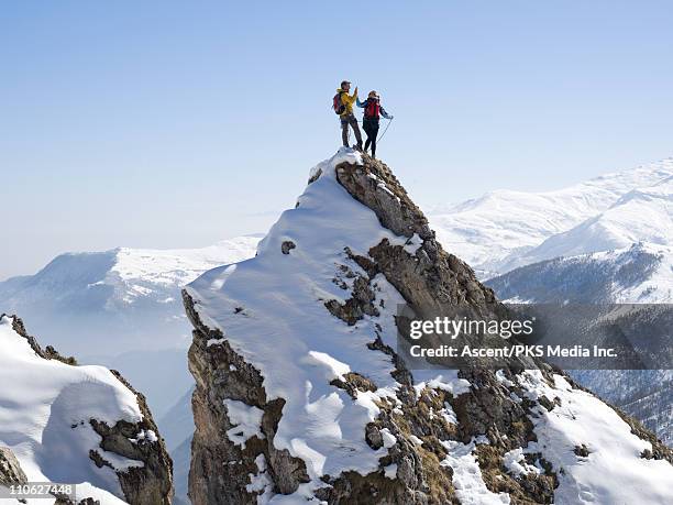 mountaineers "high-five" on summit of pinnacle - media summit fotografías e imágenes de stock