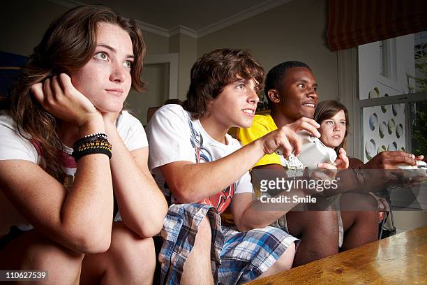 teen friends playing tv games - pre game stockfoto's en -beelden
