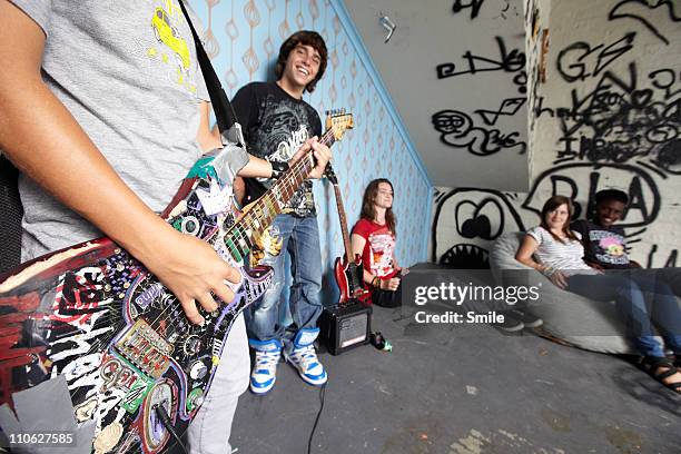 teen boy playing electric guitar for friends - tag 14 photos et images de collection