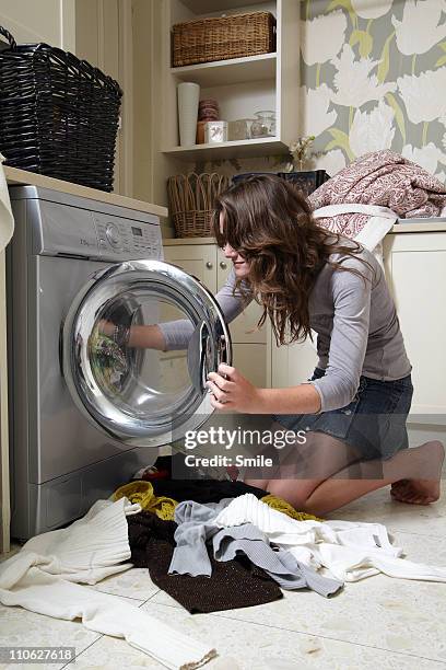Teen Girl Packing Washing Into Machine, Foto de stock