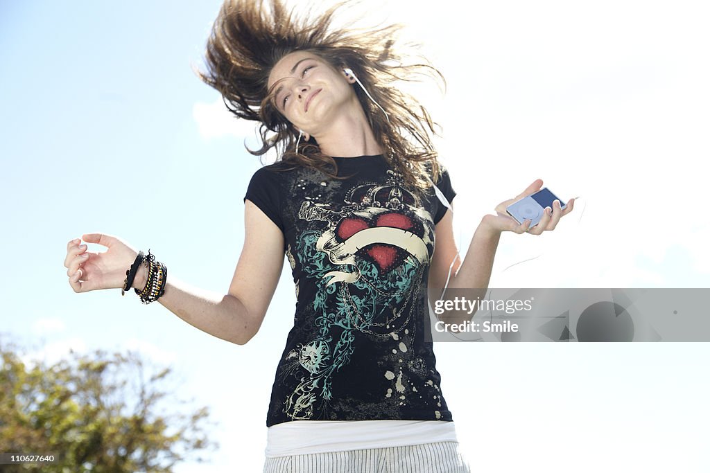 Teen girl dancing while listening to headphones