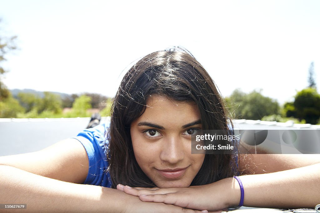 Portrait on teen girl lying on trampoline