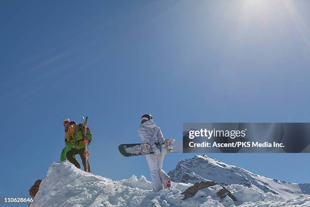 teenage snowboarder climbs ridge crest to friends - sestriere stock pictures, royalty-free photos & images