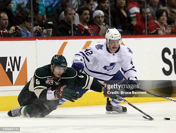 Brent Burns of the Minnesota Wild and Tyler Bozak of the Toronto Maple Leafs battle for the puck at the Xcel Energy Center on March 22, 2011 in St...