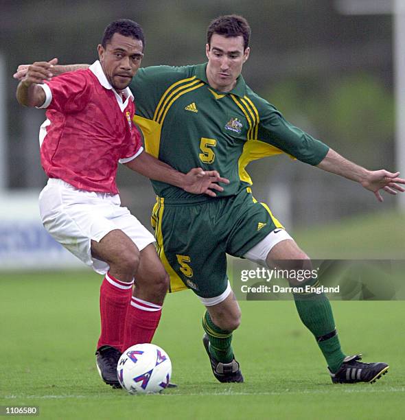 Siua Maamaloa of Tonga is tackled by Tony Vidmar of the Socceroos during the Oceania group one World Cup qualifier match between Australia and Tonga...