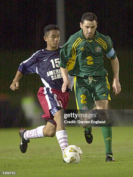 Kevin Muscat of the Australian Socceroos gets past Pati Feagiai of American Samoa during the Oceania group one World Cup qualifier match between...