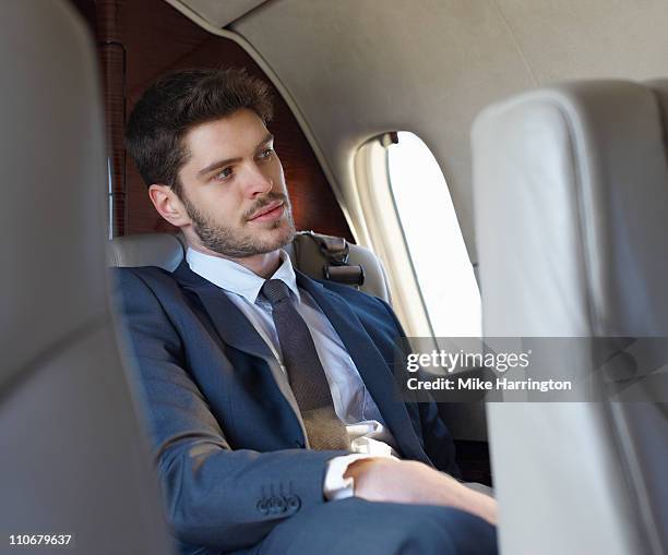 young business man on plane - 飛行機の座席 ストックフォトと画像