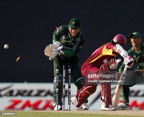 Davendra Bishoo of West Indies is bowled by Saeed Ajmal watched by wicketkeeper Kamran Akmal of Pakistan during the first ICC 2011 World Cup quarter...