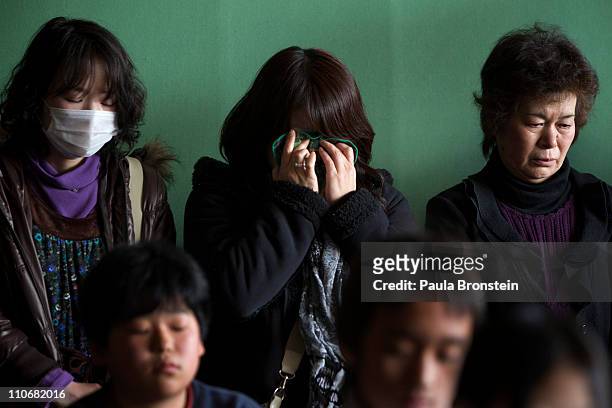 Japanese mothers weep as they attend an emotional graduation ceremony at the Ohya Elementary school March 23, 2011 in Kesennuma, Miyagi, Japan....
