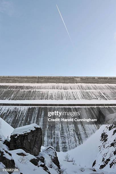 Plane flies above to the Grande Dixence Dam on March 22, 2011 in Heremence, Switzerland. Opened in 1965 after 15 years of construction, measuring 285...