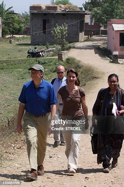 Microsoft founder and philanthopist Bill Gates and his wife Melinda walk during a visit to Jamsaut villages at Patna district in India's Bihar's...