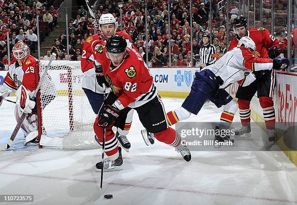 Tomas Kopecky of the Chicago Blackhawks and Alexander Sulzer of the Florida Panthers skate after the puck as Panthers' goalie Tomas Vokoun watches...