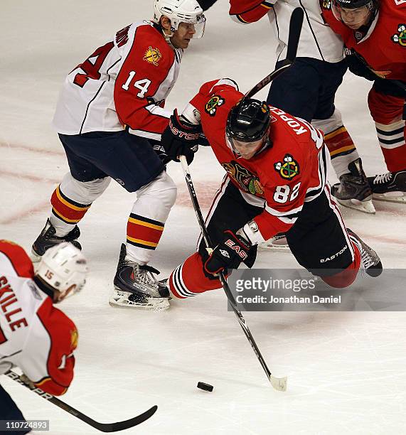 Tomas Kopecky of the Chicago Blackhawks shoots the puck between Sergei Samsonov and Jack Skille of the Florida Panthers at the United Center on March...