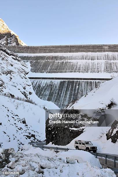 Car travels by the Grande Dixence Dam on March 22, 2011 in Heremence, Switzerland. Opened in 1965 after 15 years of construction, measuring 285...