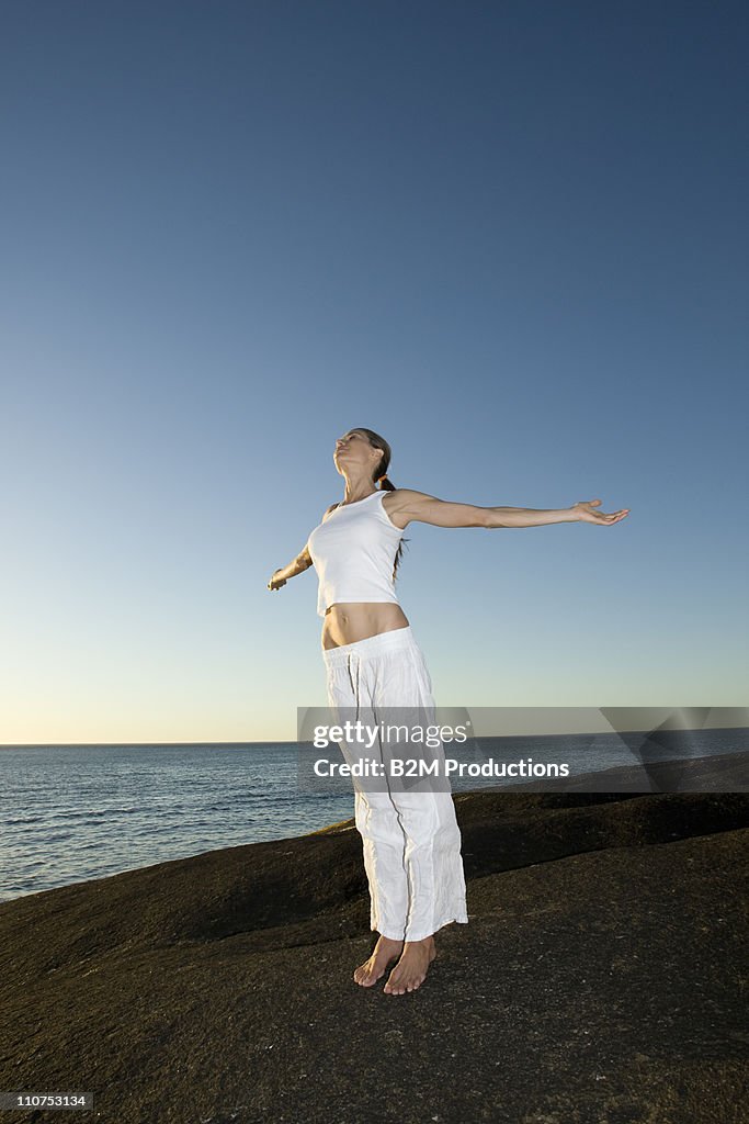 Woman practicing yoga on beach