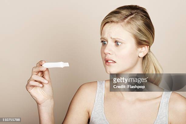 woman looking at pregnancy test - pregnancy test stock pictures, royalty-free photos & images