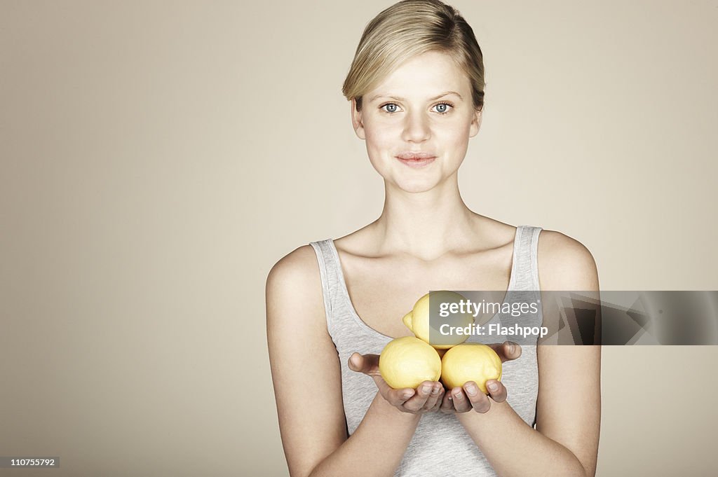 Woman holding fresh lemons