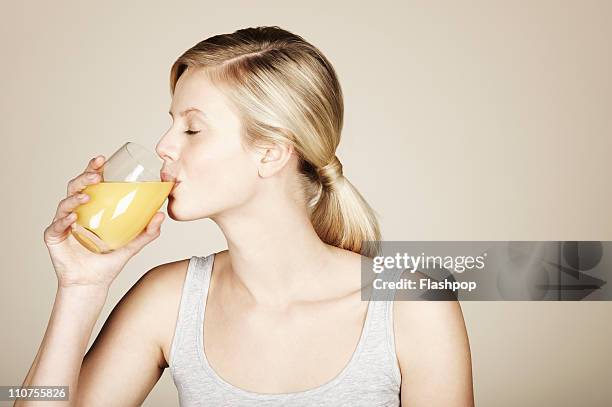 woman drinking orange juice - fruit juice stock pictures, royalty-free photos & images