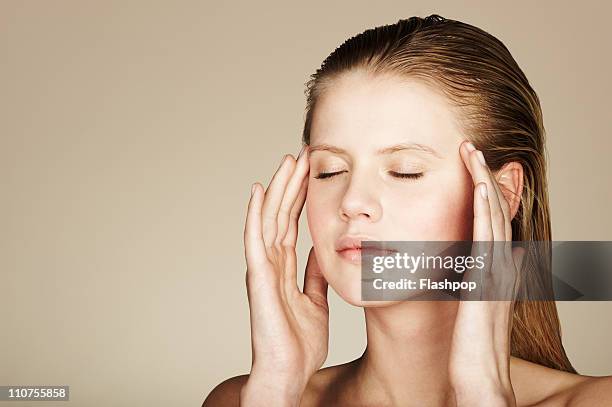 woman massaging her temples - druckpunkt stock-fotos und bilder