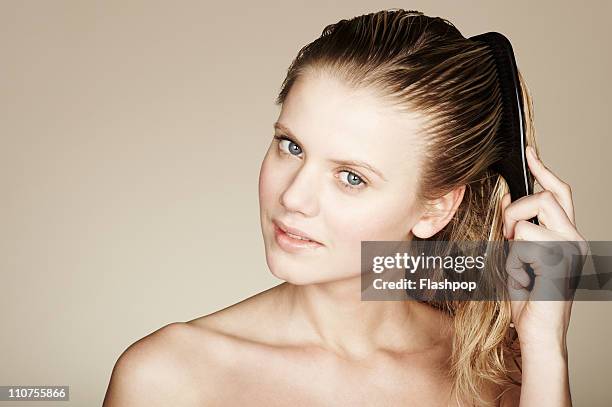 woman combing wet hair - cabello mojado fotografías e imágenes de stock