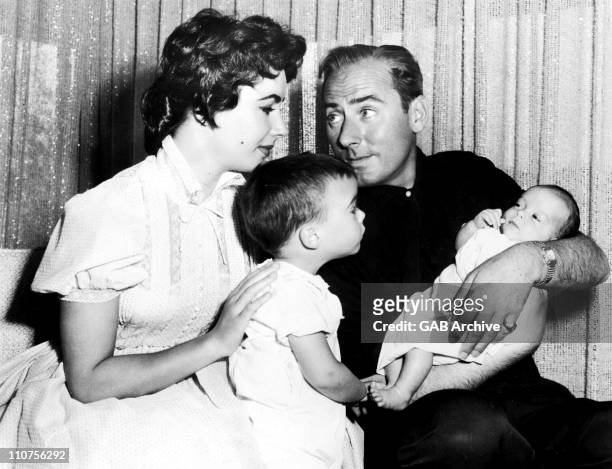 Actress Elizabeth Taylor with second husband Michael Wilding, holding son Christopher Wilding while son Michael Wilding looks on, 1955.