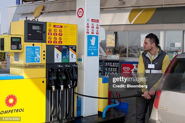 Gas station attendant fills a customer's vehicle with fuel at a Rompetrol gas station in Bucharest, Romania, on Thursday, March 24, 2011. Romania is...