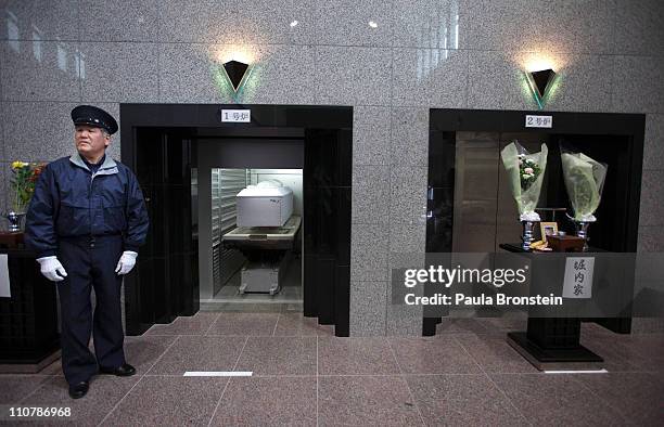Crematorium worker gets ready to close the door with the coffin of Katsuko Oyama, who was killed by the tsunami into the oven during a cremation on...