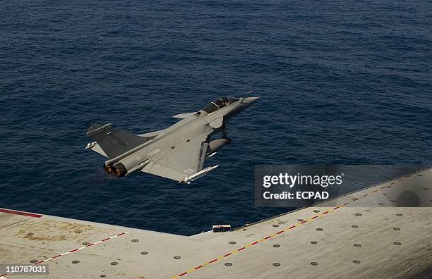 In a handout photo released by ECPAD shows a Rafale fighter jet takes off from the Charles de Gaulle aircraft carrier on March 23, 2011at sea just...
