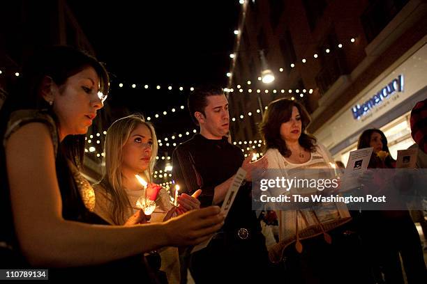 Carolina Fanning, second from left, of Potomac, MD, wipes tears away in a prayer circle as "Amazing Grace" is sung across the street from the...