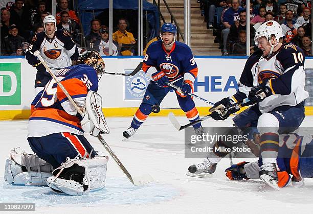 Bryan Little of the Atlanta Thrashers swats at the puck as Goaltender Al Montoya of the New York Islanders gets into position to make the save on...