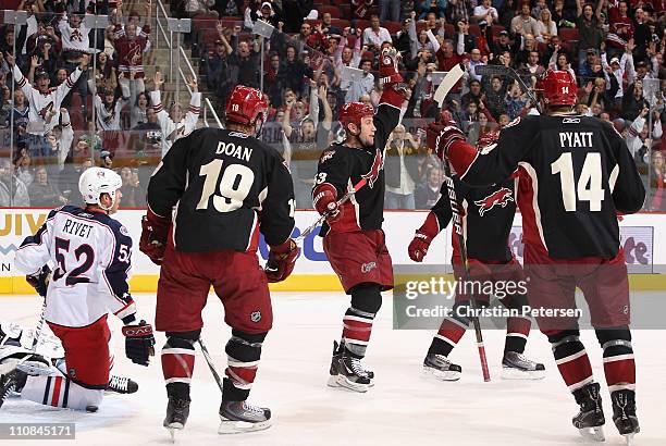 Derek Morris of the Phoenix Coyotes celebrates with teammates Shane Doan and Taylor Pyatt after Morris scored a second period goal against Craig...