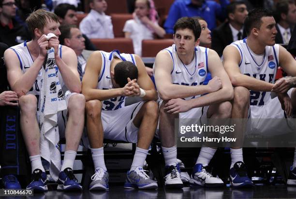 Kyle Singler, Seth Curry, Ryan Kelly and Miles Plumlee of the Duke Blue Devils look on from the bench against the Arizona Wildcats during the west...