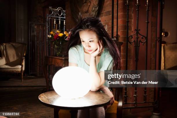 woman gazes in crystall ball. - glass ball stock pictures, royalty-free photos & images