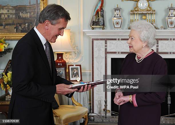 Queen Elizabeth II presents the Order of Merit to Neil MacGregor, the Director of the British Museum at Buckingham Palace on March 25, 2011 in...