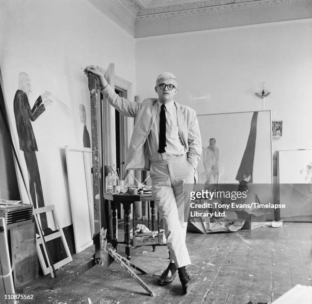 English artist David Hockney in a studio with some of his work, circa 1967.