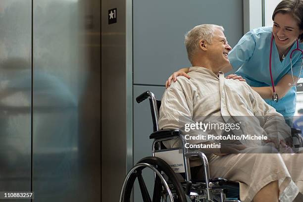 nurse helping patient in wheelchair - hospital elevator stock pictures, royalty-free photos & images