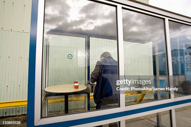 man in outdoor smoking area - windbreak stock pictures, royalty-free photos & images