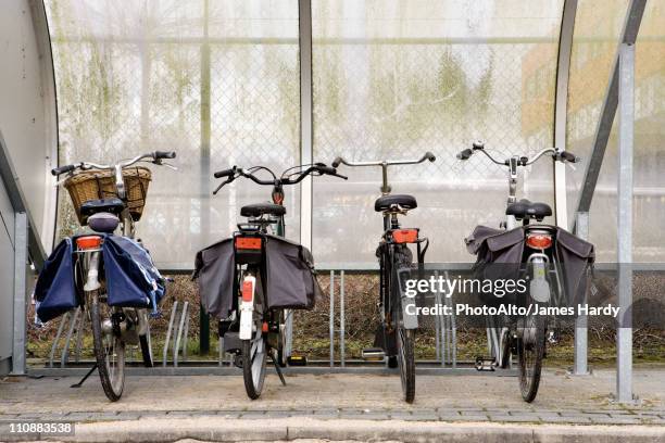bicycles parked in sheltered bicycle rack - windschutz stock-fotos und bilder