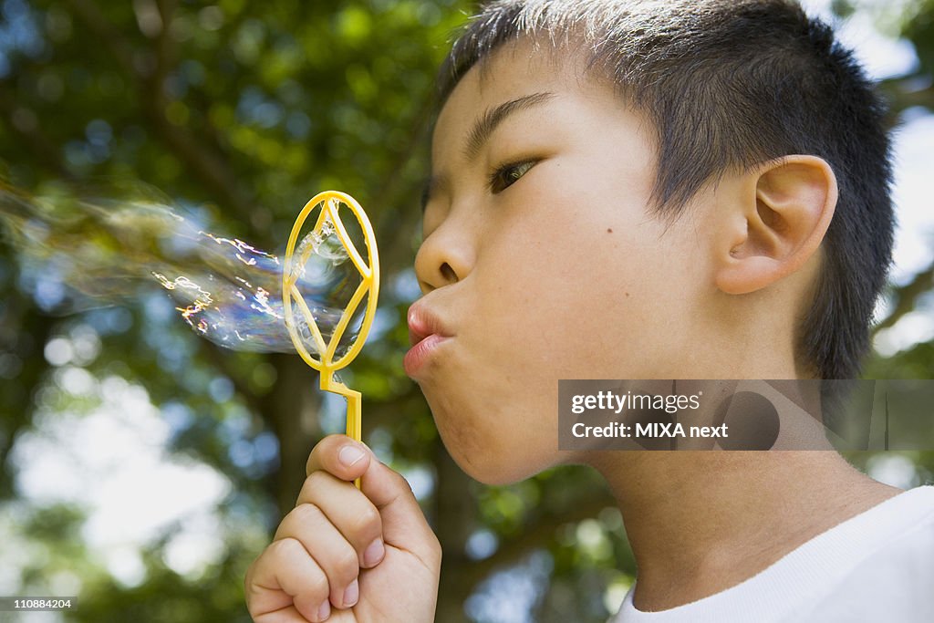 Boy Blowing Soap Bubbles