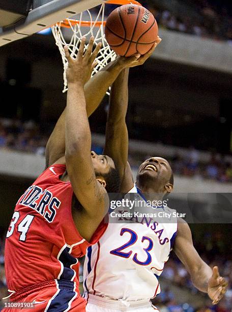 Kansas guard Mario Little blocks a shot by Richmond forward Derrick Williams during the first half in a Southwest Regional semi-final game of the...