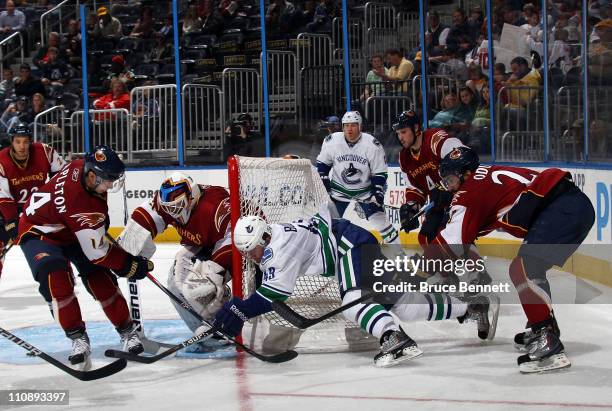 Alex Bolduc of the Vancouver Canucks is hit by Johnny Oduya of the Atlanta Thrashers at the Philips Arena on March 25, 2011 in Atlanta, Georgia. The...