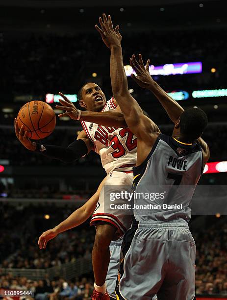 Watson of the Chicago Bulls moves around Leon Powe of the Memphis Grizzlies to put up a shot at the United Center on March 25, 2011 in Chicago,...