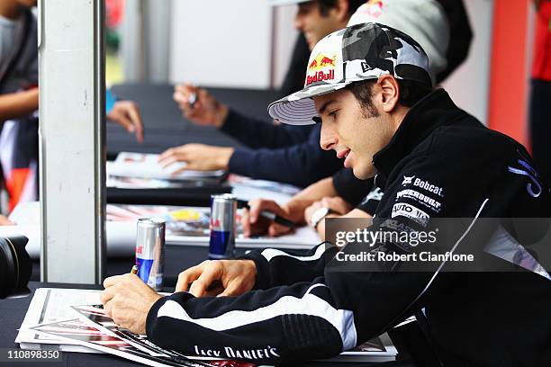 Supercar driver Rick Kelly signs autographs for fans following the Red Bull Race Off event before qualifying for the Australian Formula One Grand...