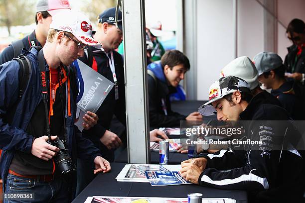Supercar driver Rick Kelly signs autographs for fans following the Red Bull Race Off event before qualifying for the Australian Formula One Grand...