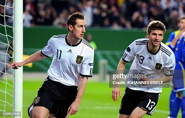 Germany's striker Miroslav Klose celebrates scoring the 1-0 goal with Germany's striker Thomas Mueller during the EURO 2012 qualifying match Germany...